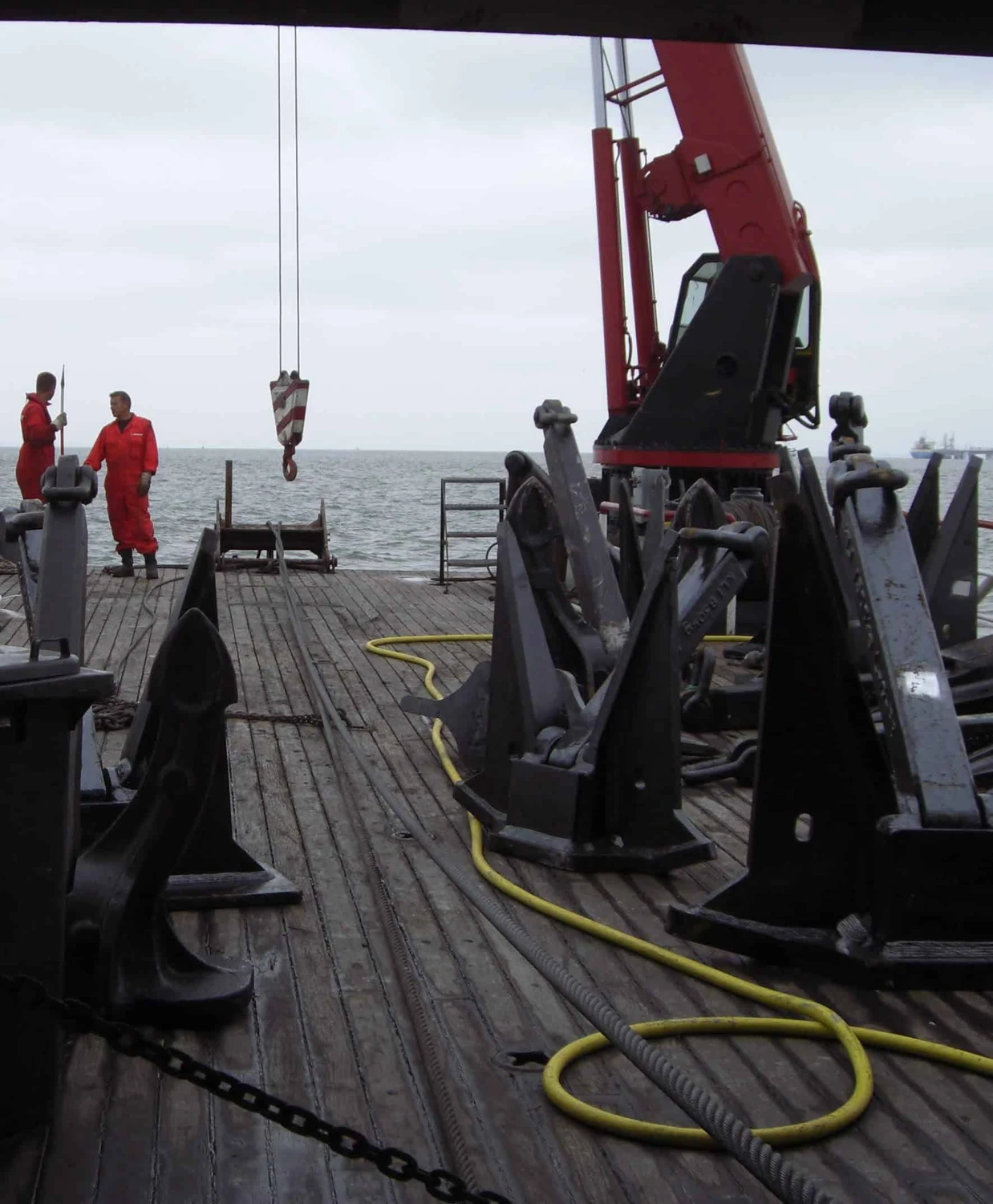 Crew members testing marine anchors on deck during type approval procedure.